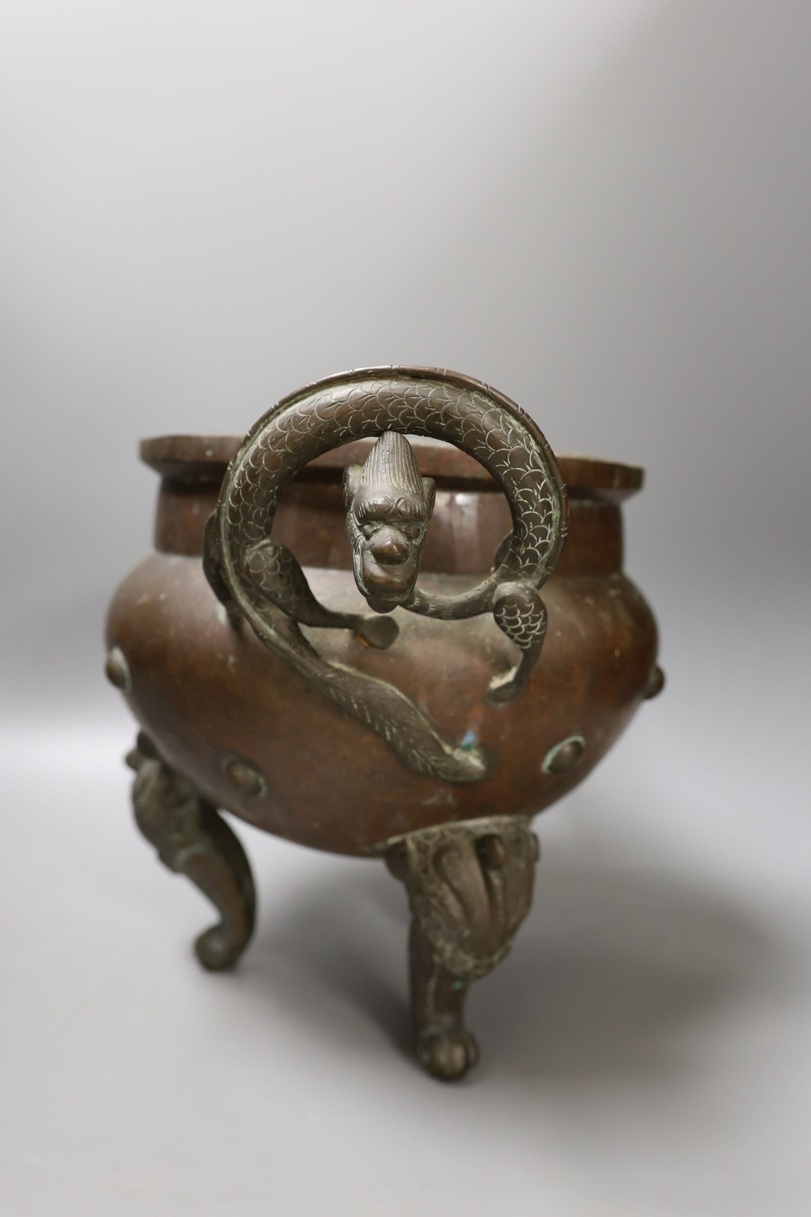 An Oriental two handled elephant footed bronze bowl, 24 cms high not including handles.